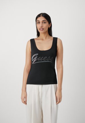 Top negro sin mangas con escote redondeado que presenta unlogotipo brillante de "Guess" en la parte frontal. Fabricado con un material liso y elástico.