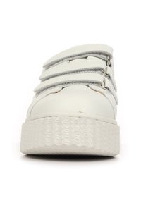 Sneaker bianco con una suola spessa e testurizzata, dotata di tre fasce in velcro e una tomaia in pelle liscia. Punta rotonda con dettagli minimi.