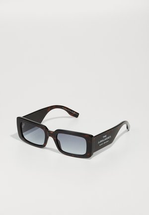 Óculos de sol oversized em tartaruga com lentes cinzentas em degradê. Apresenta um design de armação retangular e texto da marca em branco nas hastes.