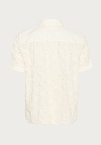 Short-sleeve shirt in off-white, featuring a textured, frayed pattern across the back, with a classic collar and button closure.