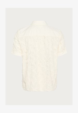 Kratka majica s kratkimi rokavi v off-white barvi, z teksturiranjem in raztrganim vzorcem na hrbtni strani, klasičnim ovratnikom in z gumbom za zapiranje.