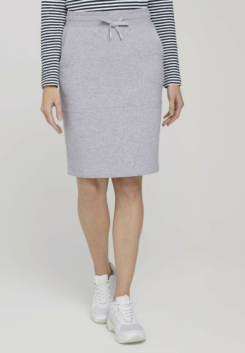 Jupe en coton gris mélangé avec une taille élastique et un cordon de serrage, longueur genoux, associée à des baskets blanches et un haut rayé noir et blanc.