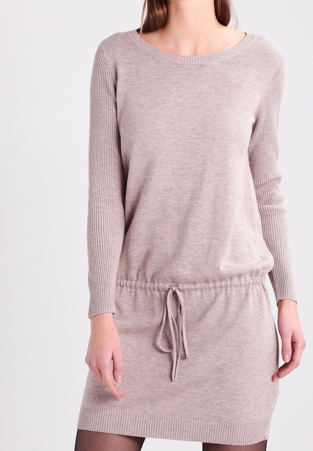 Knitklänning i ljusbeige med långa ärmar, ribbad struktur och dragsko i midjan. Har rund halsringning och en avslappnad passform.
