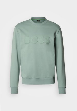 Mētru zaļš džemperis ar apaļu kaklu, ribotām aprocēm un apakšu, priekšpusē ar izcelto "BOSS" logotipu. Mīksts auduma tekstūra.