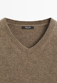 Brązowy sweter w serek, wykonany z materiału z teksturowanym splotem, z prążkowanym kołnierzem i metką z napisem "Massimo Dutti."