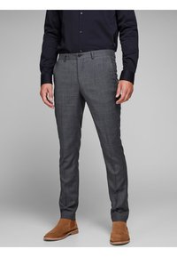 Grijze geruite broeken hebben een slim fit, ri loops, zijzakken en een rechte pijpdesign, gecombineerd met bruine suède chelsea laarzen.