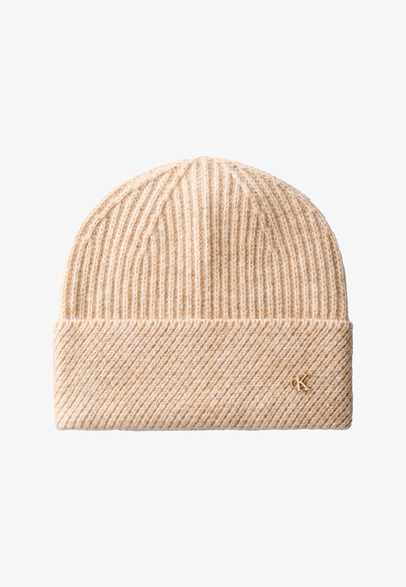 Bonnet en maille côtelée beige avec bord replié et petit logo doré "cK" sur le bord inférieur sur fond blanc.