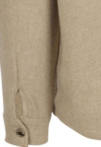 Beige wollen shirt met een getextureerde weving, knoopmanchet met een decoratieve knop en een splitdetail bij de mouw.