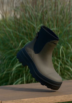 Enkelhoge laars met een matte olijfgroene bovenkant en een zwarte rubberen zool. Voorzien van een gestructureerd bovenwerk, instapontwerp en robuust profiel.