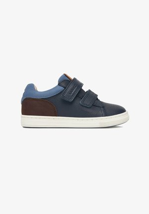 Pantof sport din piele bleumarin pentru copii, cu plasture maro la călcâi, guler bleu deschis, două barete cu scai și talpă de cauciuc albă.
