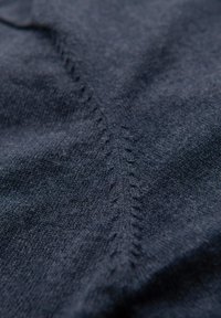 Tessuto lavorato a maglia blu navy con una texture fine e dettagli di cucitura visibili lungo una cucitura centrale. Materiale morbido ed elastico.