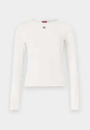 White long-sleeve top with a round neckline, featuring a small black logo on the chest, made from a smooth, stretchy fabric.