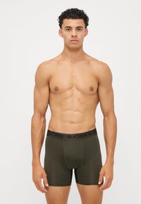 Ελιά-πράσινα μποξεράκια με μαύρη ελαστική ζώνη που φέρει το λογότυπο "BJÖRN BORG". Κατασκευασμένα από λείο, ελαστικό υλικό για άνεση.