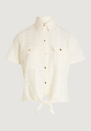 Kremowa dzianinowa bluzka z krótkim rękawem, kołnierzykiem, zapinana na guziki z przodu, z kieszeniami na piersi i wiązaniem na dole.