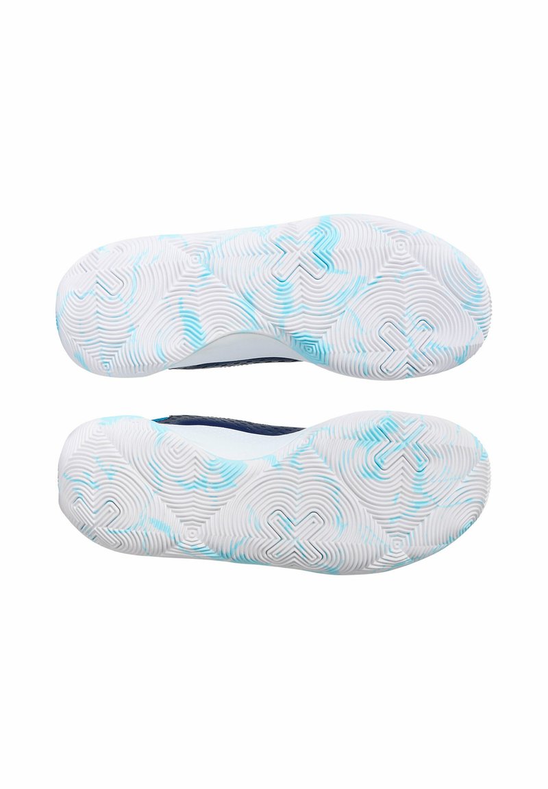 La suela del zapato presenta una goma blanca texturizada con acentos azules, diseñada con patrones circulares y un logotipo cruzado para ofrecer agarre.