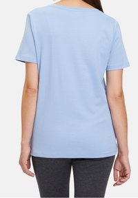 Světle modré tričko s krátkým rukávem vyrobené z měkké bavlny, s kulatým výstřihem a uvolněným střihem, z pohledu zádové strany.