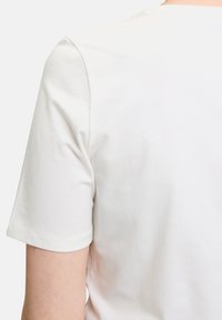 Hvid bomulds t-shirt med rund halsudskæring og korte ærmer, glat tekstur og ren syning langs kanterne.