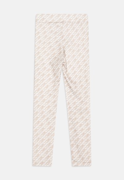 Leggings in light beige fabric featuring a repeating pattern of diagonal, slightly darker text. Smooth texture with a fitted design.