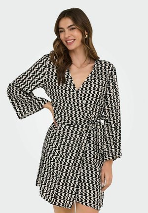 Zwart-wit gestreepte jurk met golvende patronen, met lange mouwen, een v-hals, een strikdetail in de taille, en een knoopsluiting aan de voorkant. Zachte stof en lengte boven de knie.