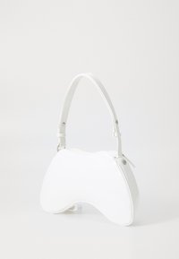 Sac à main blanc au design asymétrique unique, fabriqué en matériau synthétique lisse. Il dispose d'une courte poignée et d'un design minimaliste.