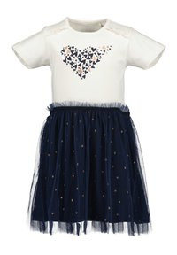 Haut blanc à manches courtes avec un motif de cœurs, associé à une jupe en tulle marine ornée de cœurs dorés et d'un ourlet volant.