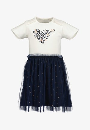 Top bianco a maniche corte con motivo a cuori, abbinato a una gonna in tulle blu navy con dettagli dorati a forma di cuore e orlo arricciato.