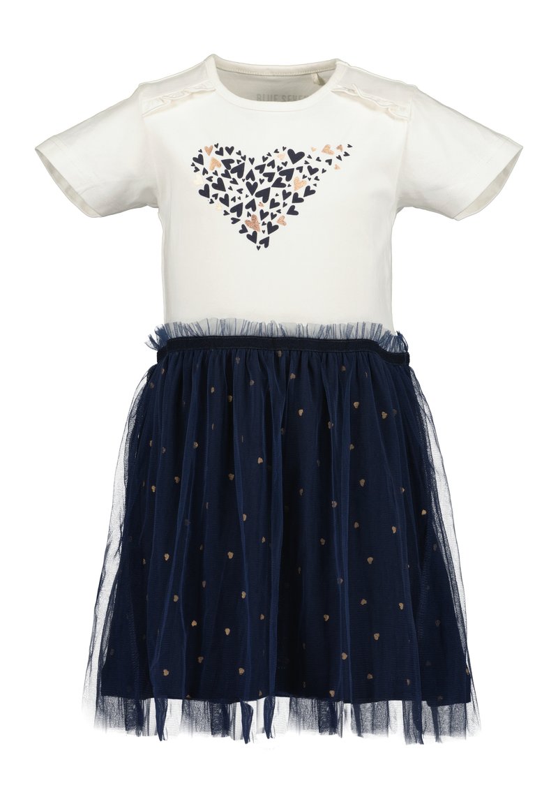 Haut blanc à manches courtes avec un motif de cœurs, associé à une jupe en tulle marine ornée de cœurs dorés et d'un ourlet volant.