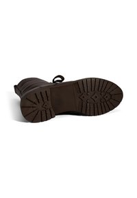 Donkere bruine leren laars ligt op zijn zij en toont een robuuste zool met diepe groeven en een trekband aan de achterkant.