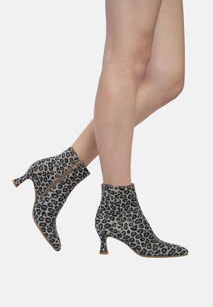 Leopard print ankle boots with a pointed toe, soft fabric, a side zipper, and a mid-height heel. Features a sleek, fitted design.