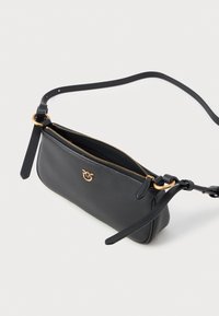 Bolsa de ombro em couro preto com fecho de zip, detalhes em dourado, alça ajustável e textura suave. Forma compacta e retangular.
