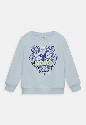 Hellblauer Pullover mit einem auffälligen Tiger-Motiv in Blau- und Gelbtönen, darunter der Schriftzug "KENZO PARIS" in einer kühnen, modernen Schrift.