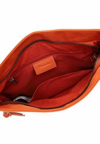 Orange fabric bag with smooth texture. Interior features red lining, a zippered pocket, and a card slot. Zip closure with contrasting stitching.