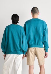 Tommy Jeans BOXY POP VARSITY CREW UNISEX - Sudadera - timeless teal