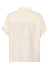 Camicia in lino leggera di colore beige chiaro, con maniche corte, polsini ripiegati e spalle dritte sulla parte superiore della schiena.