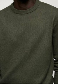 Olivgrüner Strickpullover mit rundem Halsausschnitt. Der strukturierte Stoff weist ein dezentes Rippenmuster auf. Lange Ärmel und lockere Passform.