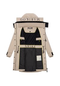 Veste extérieure beige avec une capuche, dotée d'une doublure intérieure matelassée noire, d'accents jaunes, de multiples poches et d'un logo sur le col.