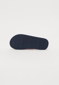 Suola di scarpa in gomma navy con nome del marchio e motivo impresso, superficie piatta e punta arrotondata. Texture per una migliore aderenza.