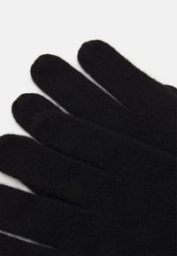 Black gloves made of a soft, textured fabric. The design features five fingers, with a smooth and seamless finish.