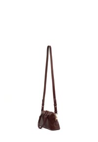 Sac à main en cuir marron de forme incurvée, avec une bandoulière amovible et des accents en métal doré. Il présente une fermeture éclair et un design minimaliste.
