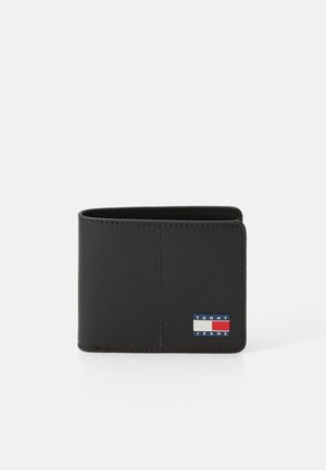 Portefeuille en cuir noir avec un design pliable. Présente un patch logo bleu, rouge et blanc à l'avant. Texture lisse et couture minimale.