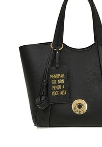 Zwarte lederen draagtas met structuur en dubbele handvatten, voorzien van een gouden cirkelaccent en een label met gele tekst. Ruim en gestructureerd ontwerp.