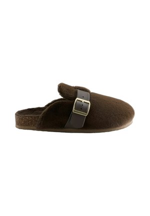 Brauner flauschiger Slipper zum Hineinschlüpfen mit verstellbarem dunkelbraunem Riemen und goldener Schnalle, flache Sohle mit korkartiger Struktur darunter.