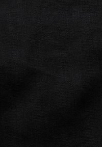 Texture de tissu en denim noir avec un motif de tissage diagonal visible et des variations subtiles d’ombrage.
