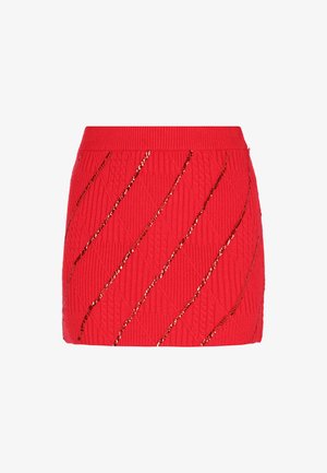 Minifalda de punto roja con un patrón de diamante texturizado y líneas diagonales adornadas con lentejuelas doradas.