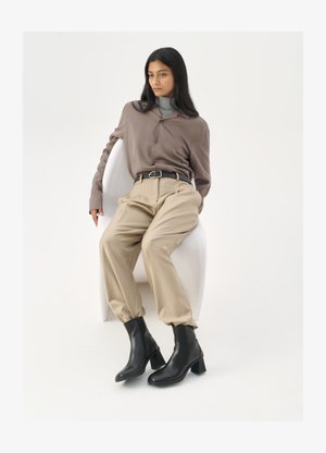 Barna ing, szürke garbó, bézs nadrág, fekete bokacsizma. Sima anyag, laza fazon, magas derék és tömbsarkú.