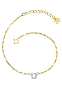 Bracelet en chaîne dorée avec un fermoir décoratif en forme de épingle de sûreté, orné de strass transparents pour plus de détail.