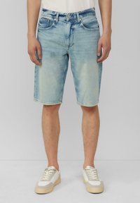 Lichtblauwe denim shorts met een reguliere pasvorm, vijf zakken, ritssluiting en een lichte vervaging. Gecombineerd met witte en beige sneakers.