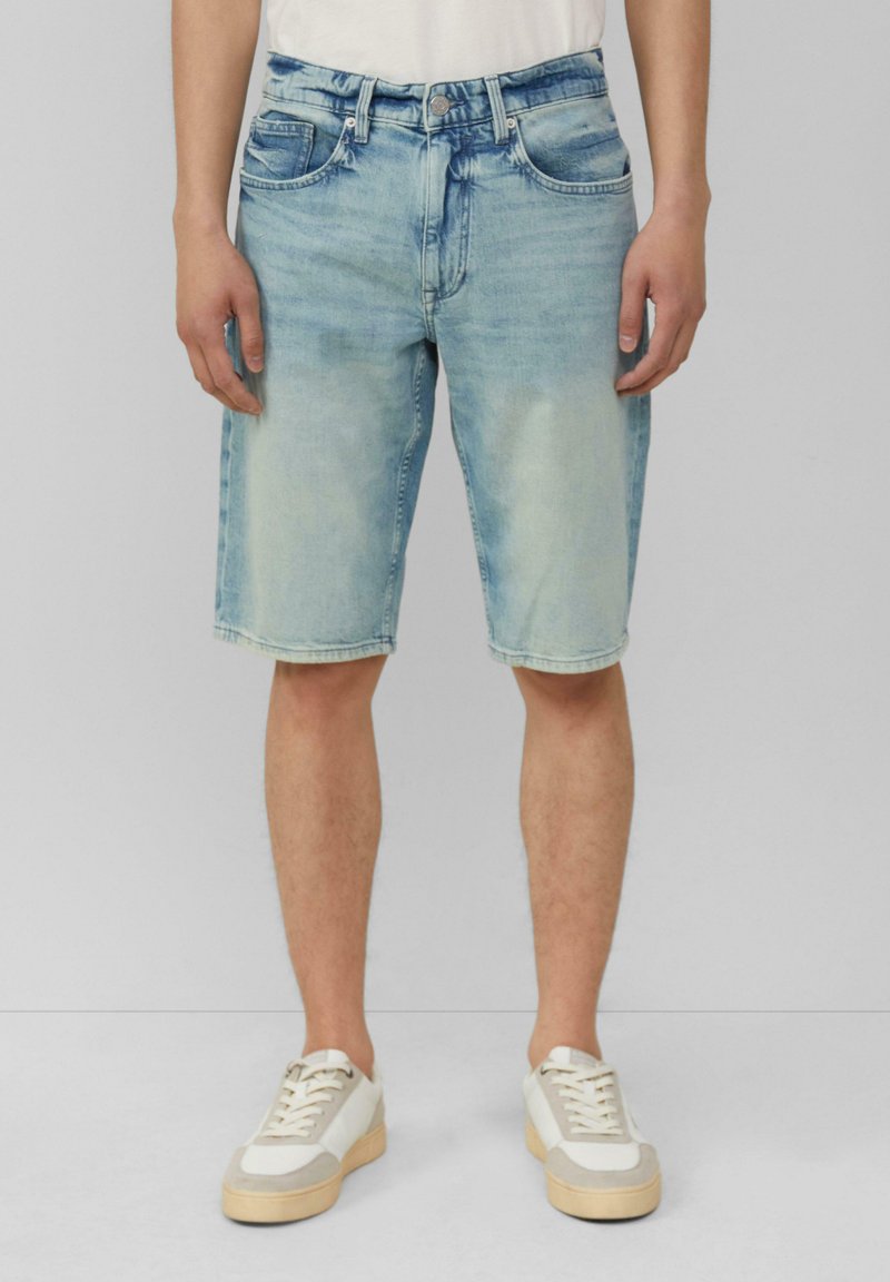 Lichtblauwe denim shorts met een reguliere pasvorm, vijf zakken, ritssluiting en een lichte vervaging. Gecombineerd met witte en beige sneakers.
