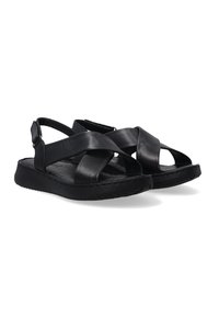 Black leather sandals featuring a cross-strap design and adjustable back buckle, with a flat rubber sole and textured insole.