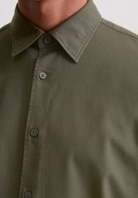 Olijfgroene short-sleeve shirt met een licht glanzende textuur, puntige kraag en zes bijpassende knopen aan de voorkant.